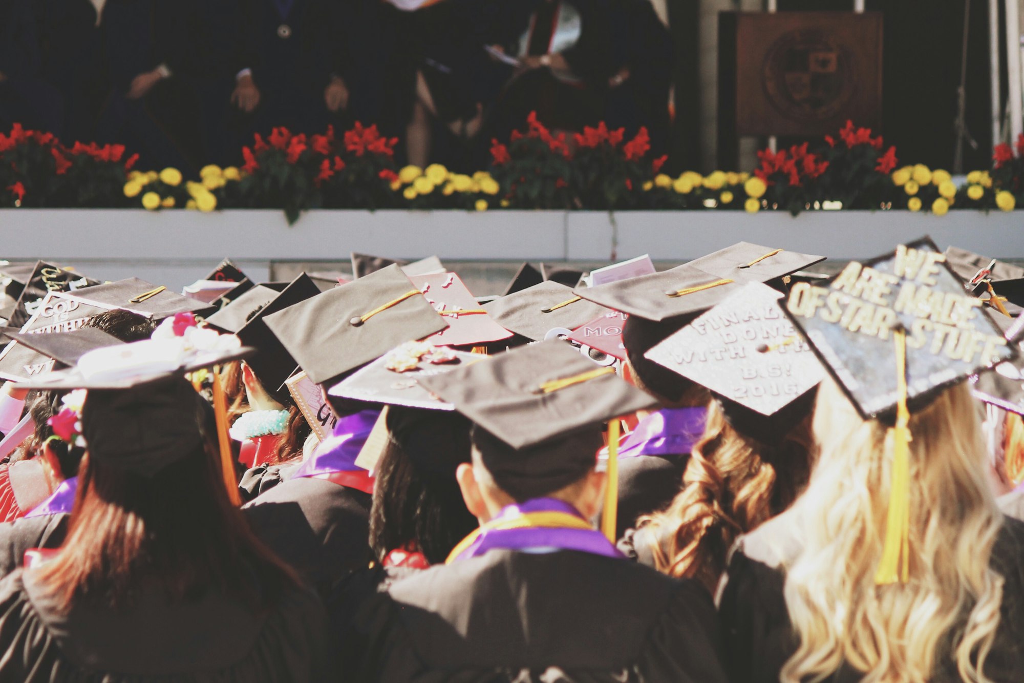 Young college high school graduates at graduation ceremony